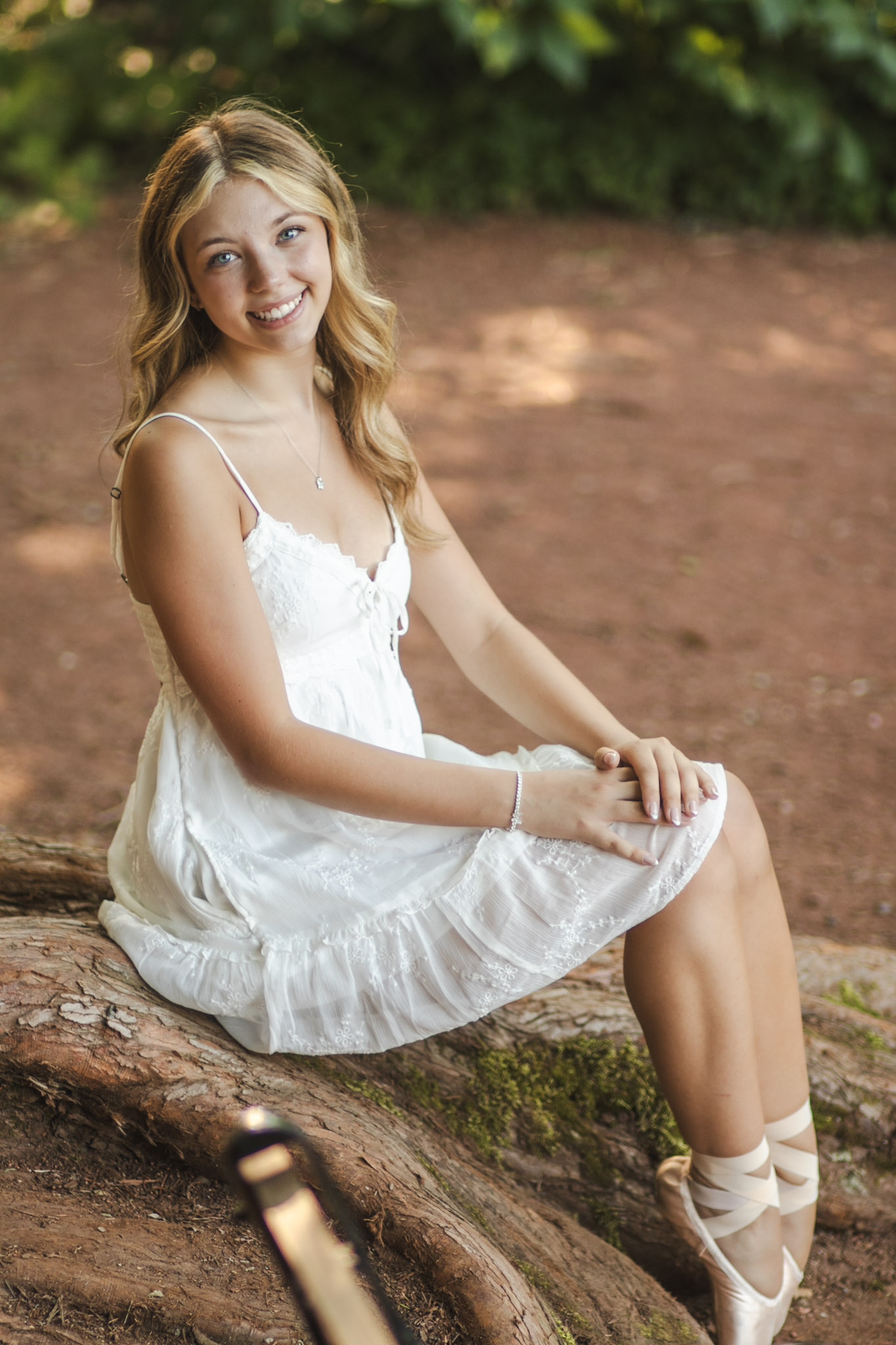 Senior portrait in a white dress outdoors